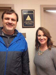 Man and woman standing in front of Ashburn Foundation plaque